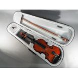 A 1/2 size violin with bow in protective case.
