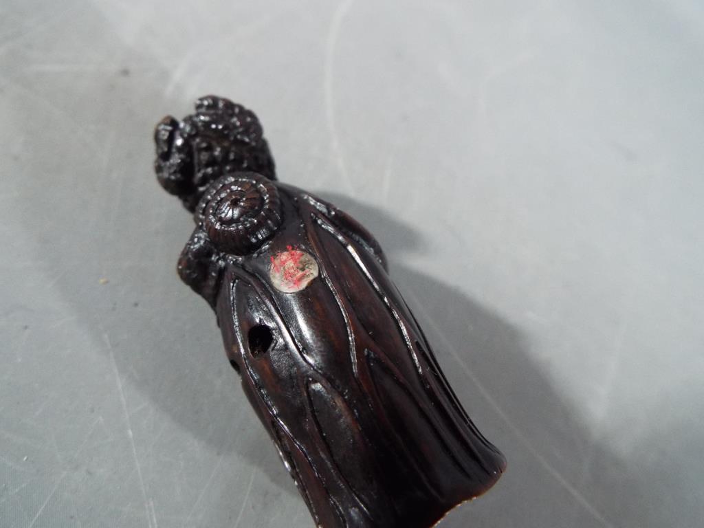 A vintage dark wood Netsuke depicting a small frog type animal carrying a large tree trunk on its - Image 6 of 6