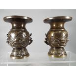 A pair of twin handled bronze vases, probably Japanese, with bird and turtle decoration,