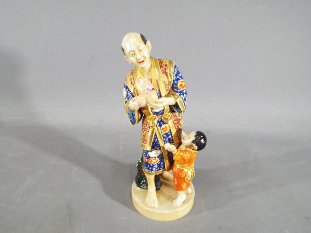 A oriental figurine of a man and boy