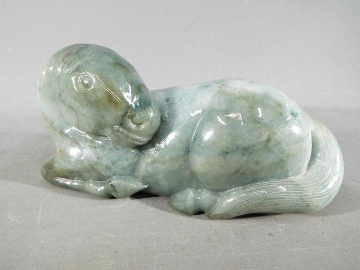 A Chinese green jade carving of a recumb