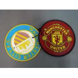 Two cast iron Manchester football plaques.
