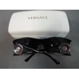 Sunglasses - a pair of sunglasses marked with Versace logos to the frames,