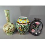 A European hand painted urn shaped ceramic vase, with a high glazed finish,