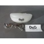 Dolce & Gabbana - a pair of designer D & G sunglasses (eye wear) with shaded glass and clear frames,