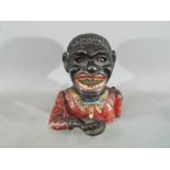 A vintage cast iron, mechanical money bank depicting a black gentleman.