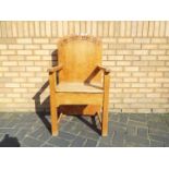 An oak armchair with carved decoration to the back rest.