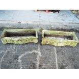 A pair of reconstituted stone serpentine front planters.
