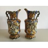 A pair of jugs with applied flower and leaf decoration both stamped to the base 725 approximate