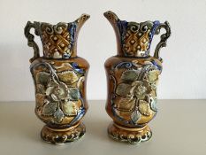 A pair of jugs with applied flower and leaf decoration both stamped to the base 725 approximate