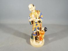 A oriental figurine of a man and boy