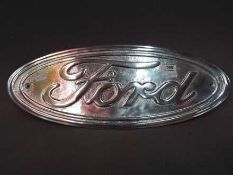A chrome sign advertising Ford motor cars