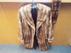A lady's fur coat, approximately 100 cm (l), slip pockets, a tear to the lining to one shoulder,