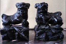 A pair of Chinese, black soapstone carvings depicting Imperial Guardian or Buddhist Lions,