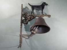 A cast bell with a depiction of a standing black dog approximately 34cms (H) x 15cms (W) x 24cms