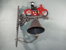 A cast bell with a depiction of a motorcyclist and veteran motorcycle approximately 38cms (H)x