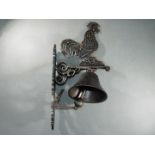 A bronzed finish cast bell with a depiction of a cockerell approximately 46cms (H )x 15cms (W) x