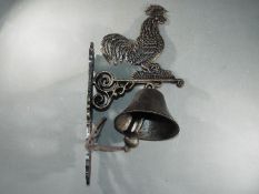 A bronzed finish cast bell with a depiction of a cockerell approximately 46cms (H )x 15cms (W) x