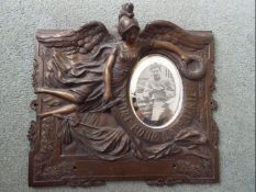 A metal wall plaque with embossed decoration,