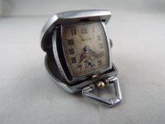 An Art Deco styled cushion form purse watch/ clock, the case with engine turned decoration,