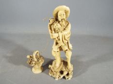 A oriental figurine of a fisherman carrying a basket