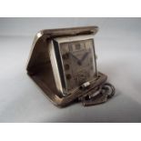 An Art Deco cushion styled purse watch or small travelling clock,