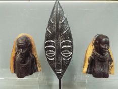 A pair of African tribal carved busts depicting a male and a female figure,