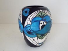 Moorcroft Pottery - a vase decorated in the Rennie Rose pattern, approximately 7.