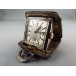 A small silver purse watch/ clock in a 36mm square cushion form case with brown leather covering,