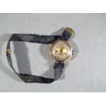 A 9 ct gold cased lady's wristwatch, stamped 9 and .375, on fabric strap, approximately 14.