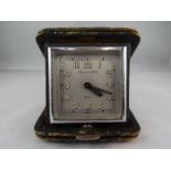 A good Mappin & Webb 8-day travelling clock in a folding green leather case,