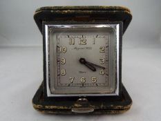 A good Mappin & Webb 8-day travelling clock in a folding green leather case,