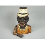 A vintage cast iron money bank of a gentleman in top hat and bow tie (arm detached).
