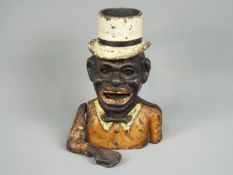 A vintage cast iron money bank of a gentleman in top hat and bow tie (arm detached).