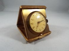 A yellow metal purse watch/ small travelling clock,