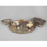 A collection of silver plated items to include a large tray raised on four bun supports, a teapot,