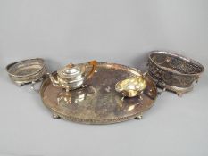 A collection of silver plated items to include a large tray raised on four bun supports, a teapot,