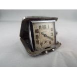A small folding purse watch/ clock in a white metal cushion form case 36mm square engine turned Art