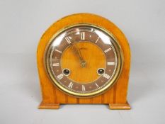 A small Smiths wood cased mantel clock with Roman numeral chapter ring, movement marked 'Smiths'.