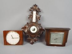 A Kienzle automatic clock and two barometers.