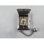 An Art Deco styled cushion form purse watch/ clock,