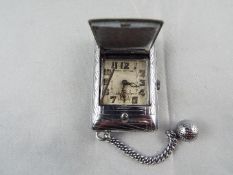 An Art Deco styled cushion form purse watch/ clock,