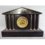 A continental mantel clock of architectural form flanked by reeded columns,