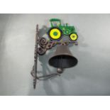 A cast bell with a depiction of a green tractor approximately 37cms (H) x 14cms (W) x 23cms (D)