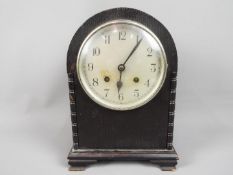 An arch top mantel clock with Arabic numerals to the dial, with key and pendulum.