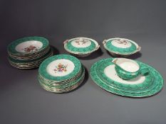 An Empire China dinner service with floral decoration within a green border, 32 pieces in total.