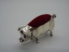 A silver pin cushion in the form of a pig