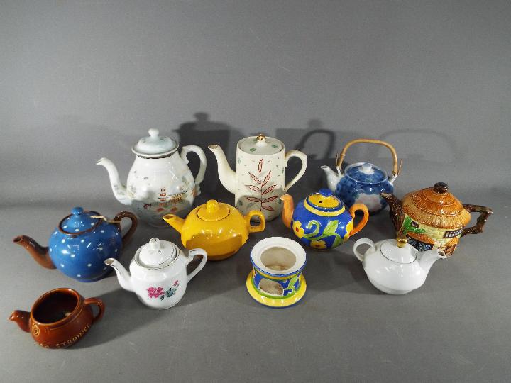 A quantity of teapots and similar to include Beswick, Oriental examples and other.