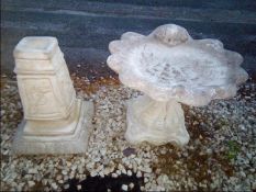 A reconstituted stone bird bath in the form of a shell and a garden ornament
