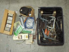 A large tub containing a quantity of clamps, hinges, a boxed corner cramp, tools, steel wool,